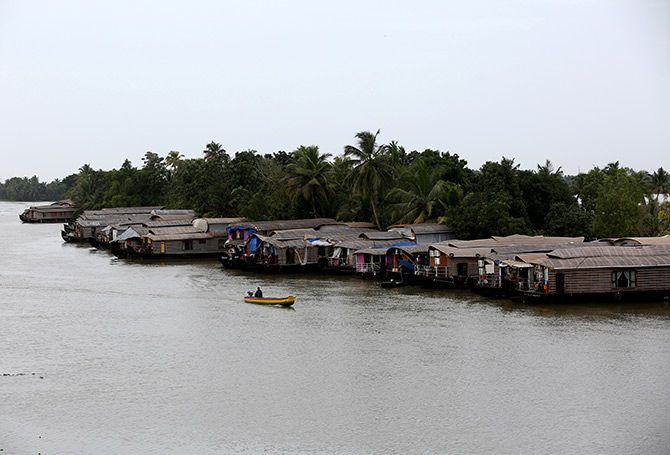 A motorboat moves past a row of empty houseboats in a tributary of the Pamba river following floods in Alappuzha district in the southern state of Kerala in August. Photograph: Sivaram V/Reuters.