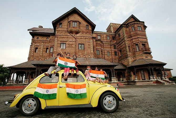Children hold Indian national flags as they sit on a car in front of Hari Palace, Jammu. Photograph: Mukesh Gupta/Reuters.
