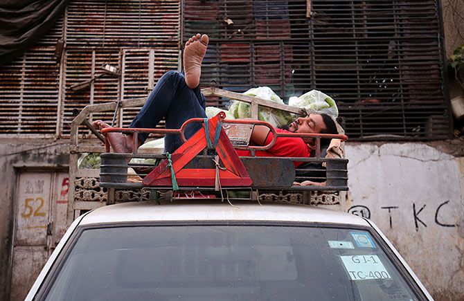 Snoozing aboard a mini truck in Ahmedabad. Photograph: Amit Dave/Reuters
