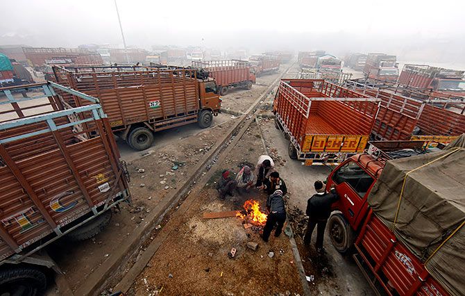 Truck drivers warm themselves during a bitter New Delhi winter. Photograph: Adnan Abidi/Reuters.