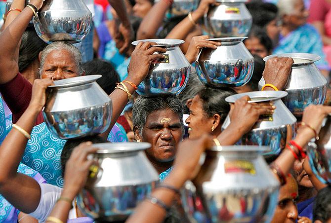 Milk being carried on the beach at Chennai. Photograph: Babu/Reuters.