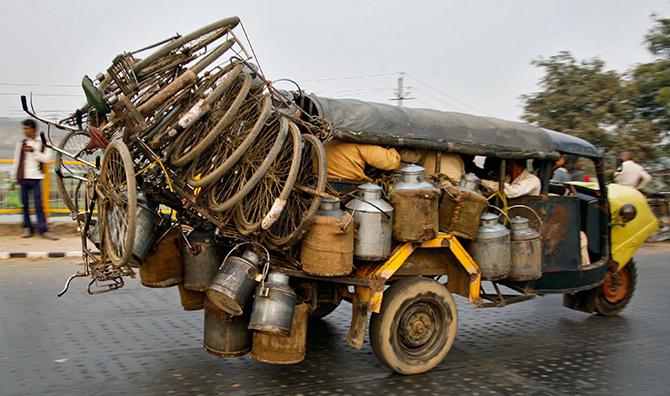 A gaggle of milk sellers headed to the market with their milk cans and bicycles in Allahabad, Uttar Pradesh. Photograph: Jitendra Prakash/Reuters.