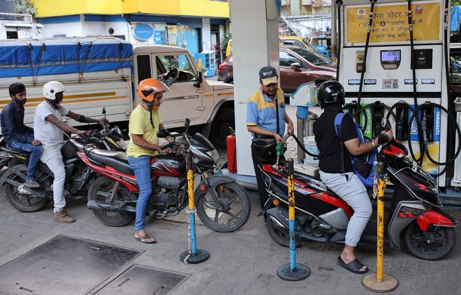  A man pumps petrol into a scooter at a fuel station in Mumbai