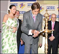 Lara Dutta looks on as Amitabh Bachchan lights the inaugural lamp at FICCI Frames 2005