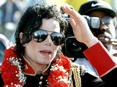 Michael Jackson shields his eyes from the sun as he arrives at Johannesburg International airport