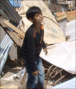 Azhar next to the debris of his home