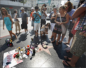 People gather around the star of the late Michael Jackson on the Walk of Fame in Hollywood