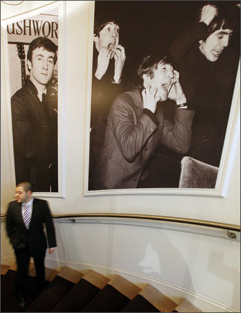 A man passes pictures of the Beatles on the main staircase at the Hard Days Night Hotel in Liverpool