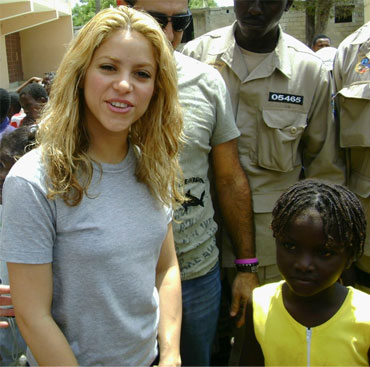 Shakira stands next to an earthquake survivor