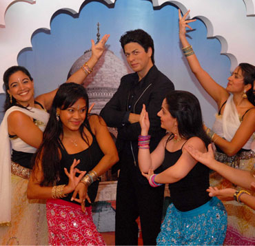 Bollywood Axion Dance Troupe perform around the wax figure of Shah Rukh Khan