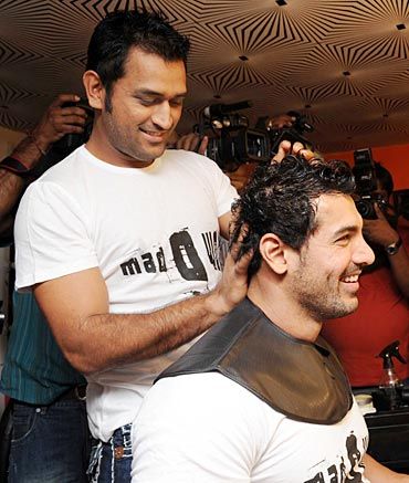 Mahendra Singh Dhoni plays with John Abraham's hair during a promotional event at Sapna Malhotra's Mad-O-Wat salon in Mumbai, December 2010.