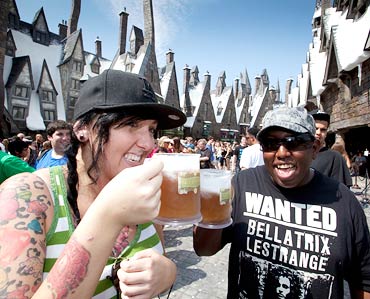 Visitors drink butterbeer during the grand opening