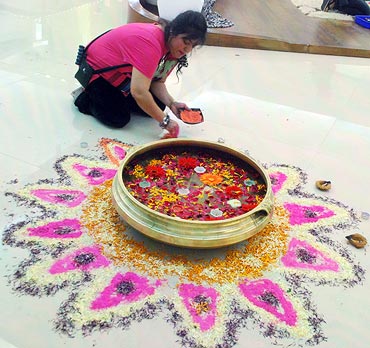 Housemates decorate the house with a rangoli
