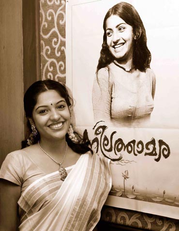 Archana Kavi posing in front of Neelathamara's poster