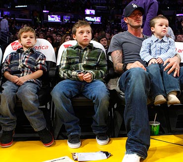 David Beckham watches an NBA basketball game with his sons (left to right) Romeo, Brooklyn and Cruz