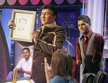 Judge Anu Malik shows one of Dhaval's paintings