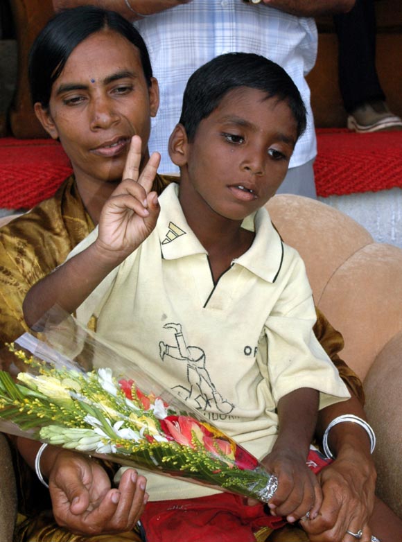 Budhia Singh, a four-year-old child (L), sits with his mother Sukanti after a marathon in the eastern Indian city of Bhubaneswar