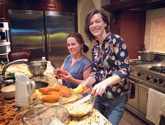 Milla Jovovich in her kitchen with a friend
