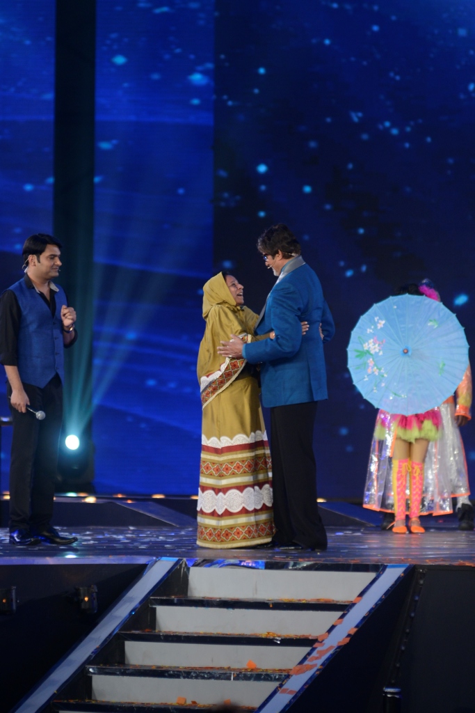 Amitabh Bachchan hugs a fan at the premiere of Kaun Banega Crorepati while Kapil Sharma looks on