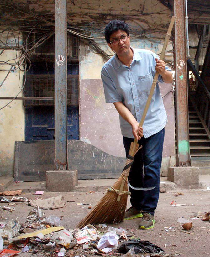 Prasoon Joshi cleans the streets outside the Sofi Mahal building in Lalbaug, South Mumbai, as part of Prime Minister Narendra Modi's Swachh Bharat Abhiyan. Photograph: Sahil Salvi