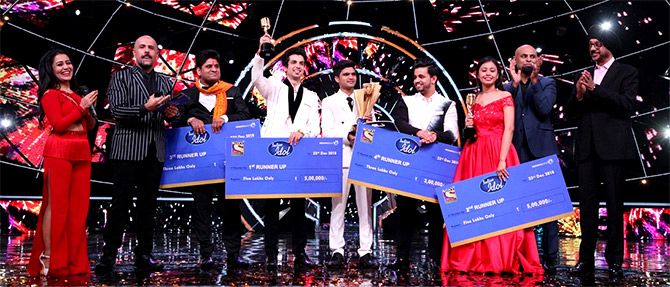 The top five finalists of Indian Idol, Season 10, with hosts Neha Kakkar and Vishal Dadlani, left and second from left, and others