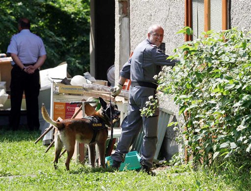 Police at the house where the four infants were found in the basement freezer and in paint cans.  (AP Photo)