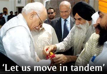 A Pakistani Sikh offers a garland to BJP chief LK Advani, on his arrival to visit a Sikh temple in Lahore, Pakistan on Friday, June 3, 2005. AP Photo/K M  Chaudhry