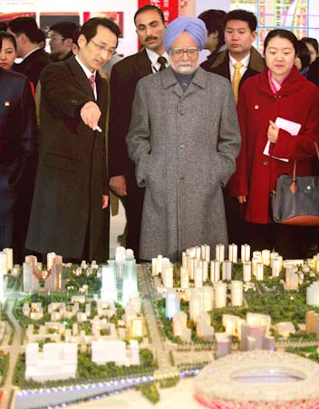 Prime Minister Manmohan Singh looks on as Beijing Vice-Mayor Chen Gang (Left) introduces a model of the Olympic Green in Beijing, China