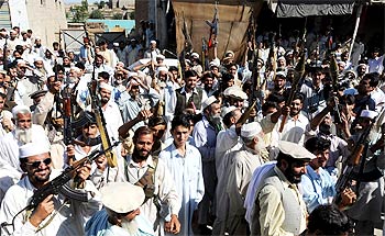 Pakistani men from tribal forces chant slogans against the Taliban in Raghagan