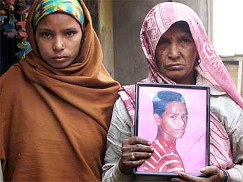 The blind mother and younger sister of 20-year-old Pradeep Singh hold a picture of him. He died after suffering severe beating by the police in Chitti, Dhankaur. They still have received no compensation