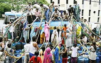 Residents of Sanjay Colony, a residential area, crowd around a water tanker in New Delhi.