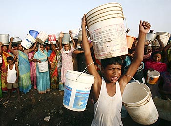 Slum dwellers carry empty containers during a protest in Chandigarh.