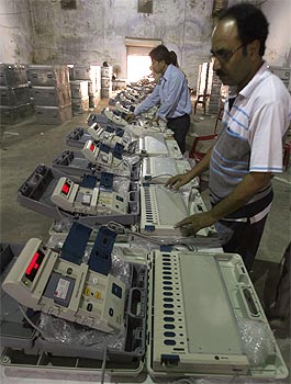 Technicians check EVMs at an election office
