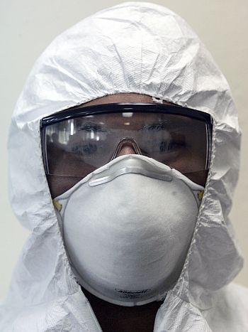 A hospital worker models a biohazard suit, safety goggles and a mask in San Salvador