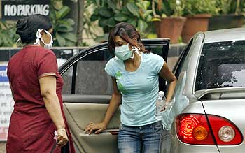 People wearing masks arrive outside a special ward for H1N1 influenza testing at the Kasturba Hospital in Mumbai
