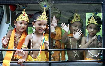 School children dressed as Krishna wave from inside a bus on the eve of Janamashtmi celebrations in Chandigarh