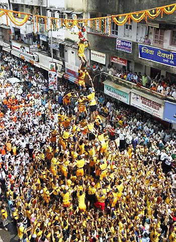 Devotees form a human pyramid to reach a clay pot containing butter during the celebrations