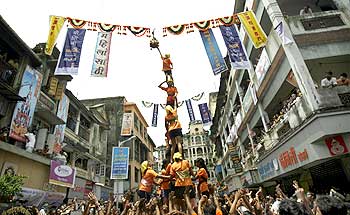 Female devotees form a human pyramid to break a clay pot containing butter during the celebrations