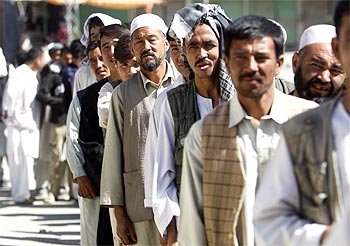 Men queue up to vote in the presidential election at a polling station in Kabul