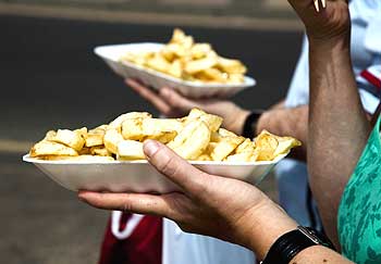People eat chips while walking along a promenade