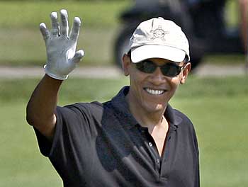 US President Barack Obama waves as he plays golf at Farm Neck Golf Course at Oak Bluffs in Martha's Vineyard, Massachusetts.
