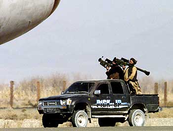 Taliban soldiers hold Stringer surface-to-air missiles as they pass close to the aircraft