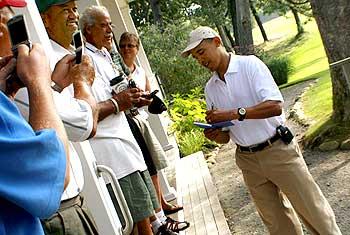 Obama signs autographs for golfers before his round of golf at Mink Meadows Golf Club