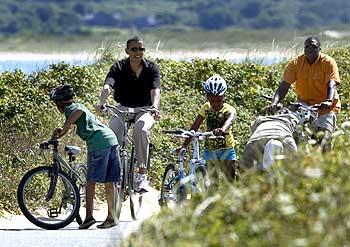 Obama rides a bike with his daughter Sasha (Centre) in Aquinnah on Martha's Vineyard