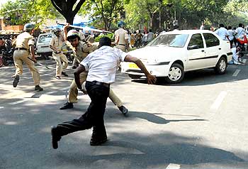 A protestor tries to evade the cane