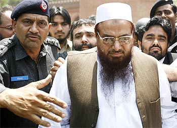 Police escort Hafiz Sayeed, head of the banned Jamaat-ud-Dawa and founder of Lashkar-e-Tayiba, as he leaves after an appearance in court in Lahore