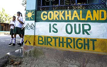 Schoolgirls walk past a graffiti demanding statehood for Gorkhaland at Sukuna in Darjeeling