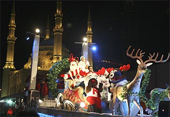 A float carrying performers dressed as Santa Claus and his assistants tours in front of al-Amin mosque during a Christmas parade in downtown Beirut