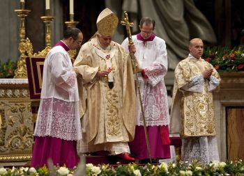 Pope Benedict XVI is assisted as he leads the Christmas mass in Saint Peter's Basilica at the Vatican