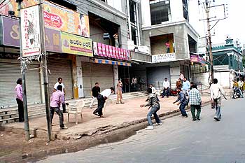 People play cricket on the deserted roads